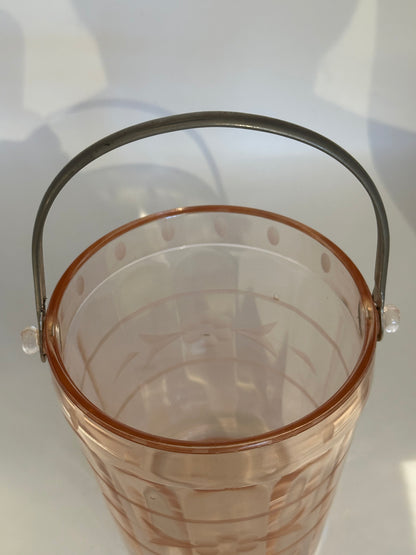 Pink glass ice bucket viewed from above with arched metal handle