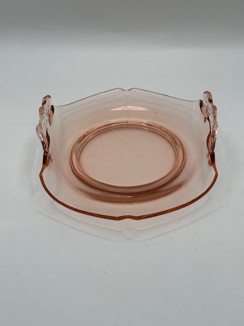 Top view of pink glass dish showing etched center and clear scroll handles