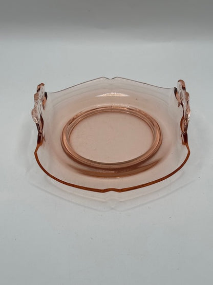 Top view of pink glass dish showing etched center and clear scroll handles