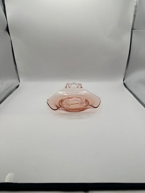 Pink depression glass dish centered in a white light box