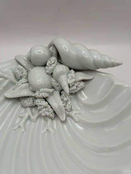 Close-up of the molded seashells, conch and starfish detail on the white porcelain shell dish