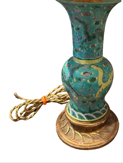 Close-up of the turquoise porcelain lamp body with yellow-and-green dragon design and carved giltwood base