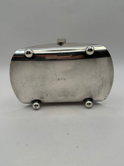 Underside of the silver-plate basket showing ball feet and faint maker's marks