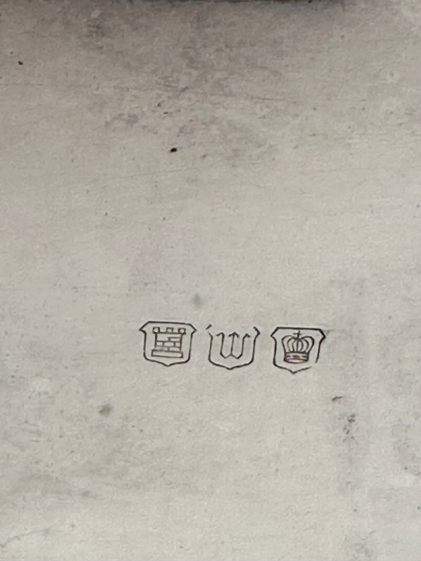 Close-up of the basket's hallmarks: a tower, the letter 'W', and a crown in shields