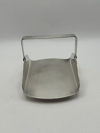 Silver-plate basket with its swing handle raised, showing the curved square dish