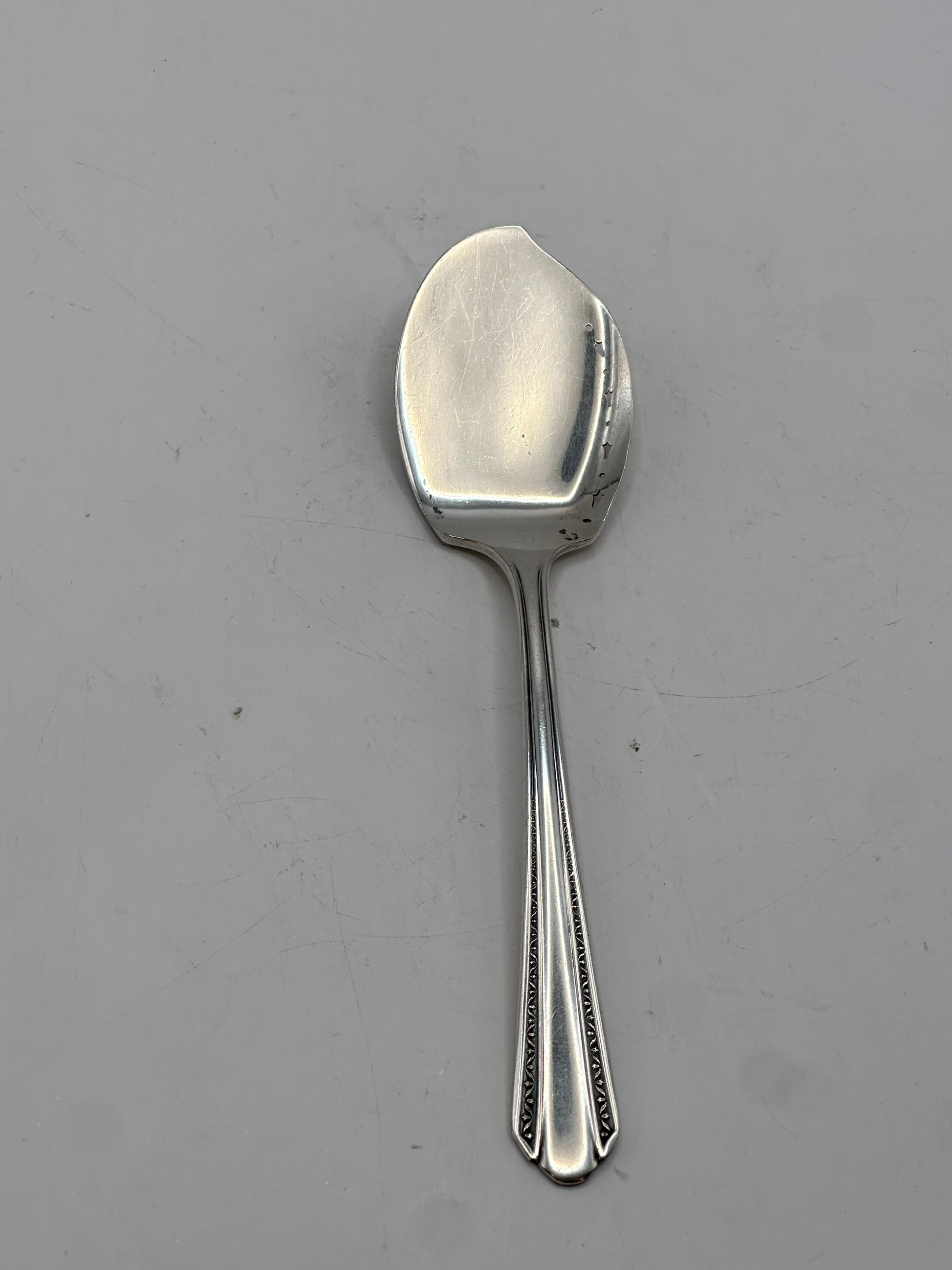 Angled view of the aspic spoon's wide flat serving bowl
