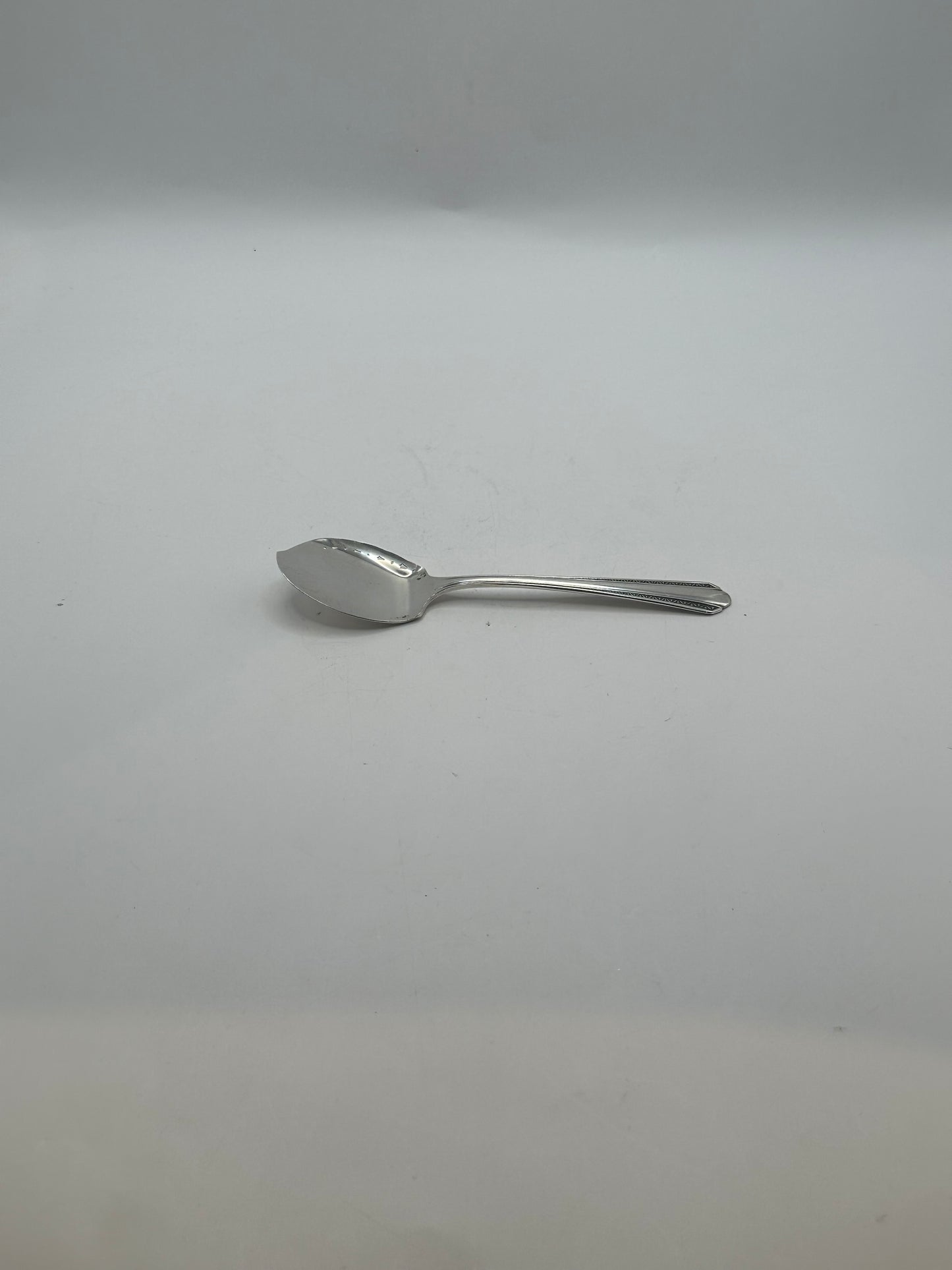 Side profile of the silver-plate aspic spoon showing its angled flat bowl
