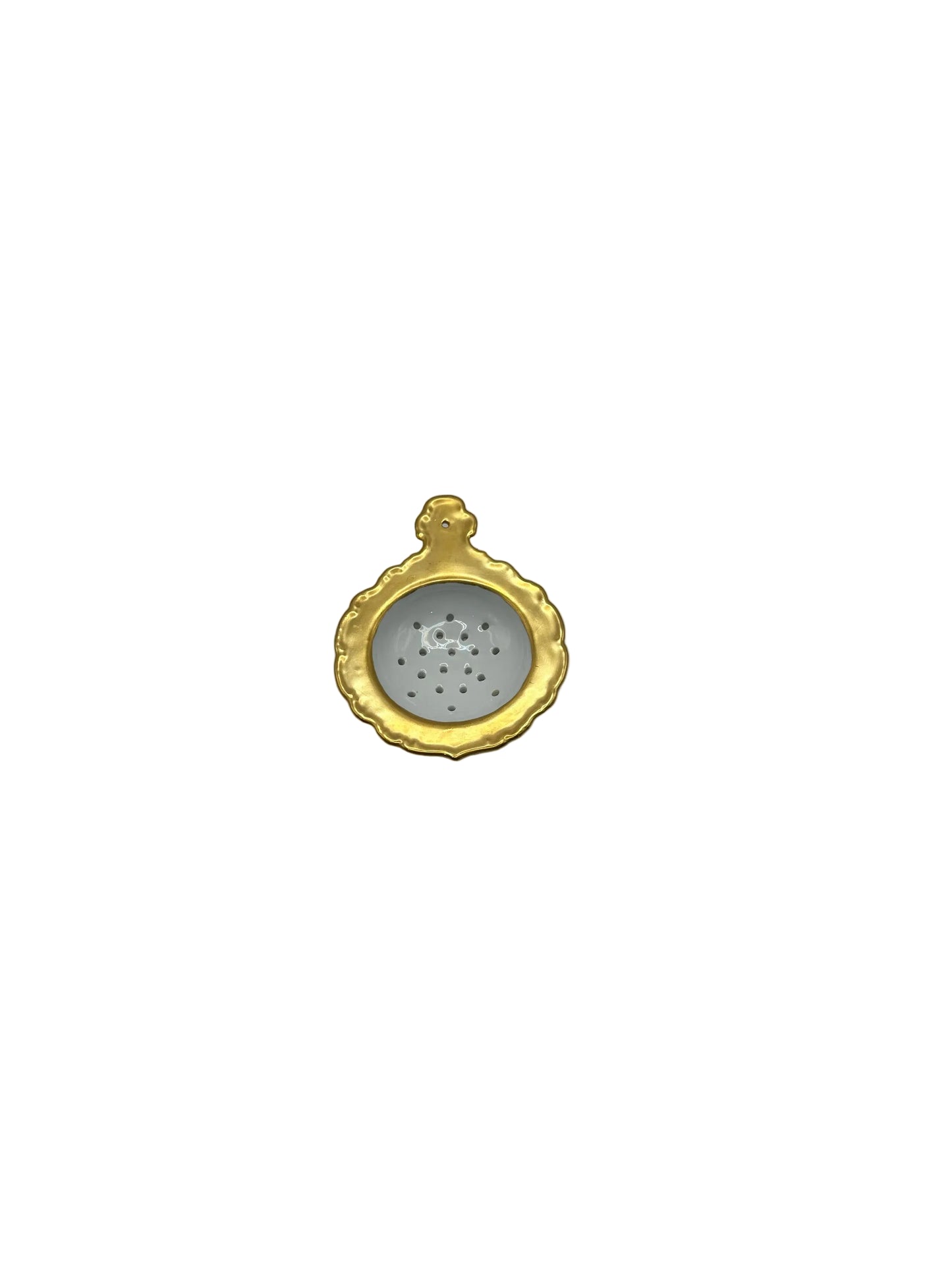 Porcelain tea strainer with a gold scalloped rim, top-down view into the perforated bowl