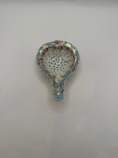 Top-down view into the floral porcelain tea strainer's perforated bowl