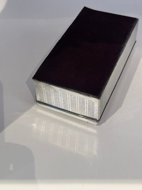 Angled view of the closed cigarette box showing its reflective lid and ribbed sides