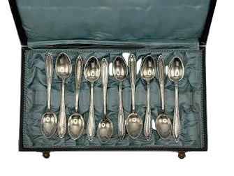 Set of silver-plate demitasse spoons arranged in a teal satin-lined presentation case
