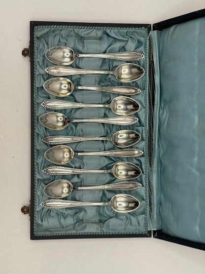 Full set of demitasse spoons arranged in the satin-lined presentation case