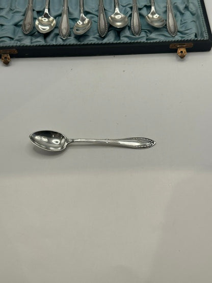 A single demitasse spoon removed and placed beside the open case
