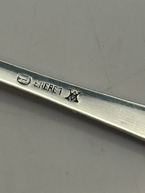 Close-up of a spoon's back stamped 'ENERET' with a Danish maker's mark