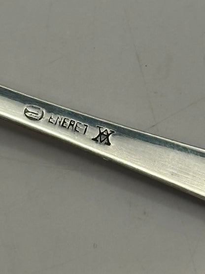 Close-up of a spoon's back stamped 'ENERET' with a Danish maker's mark