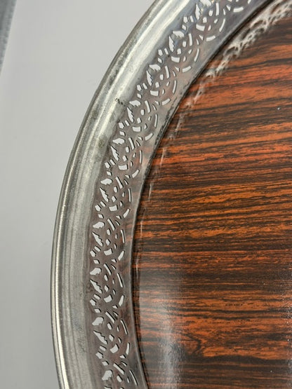 Detail of the pierced gallery rim against the rosewood tray surface