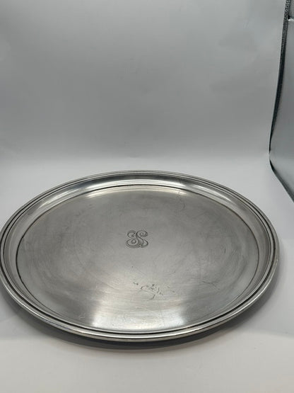 Angled view of the round silver-plate tray showing its polished surface and raised rim