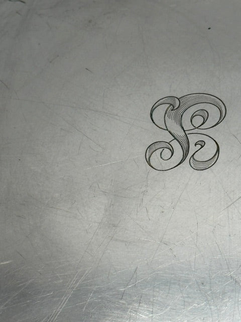 Detail of the engraved script monogram on the tray's silver surface