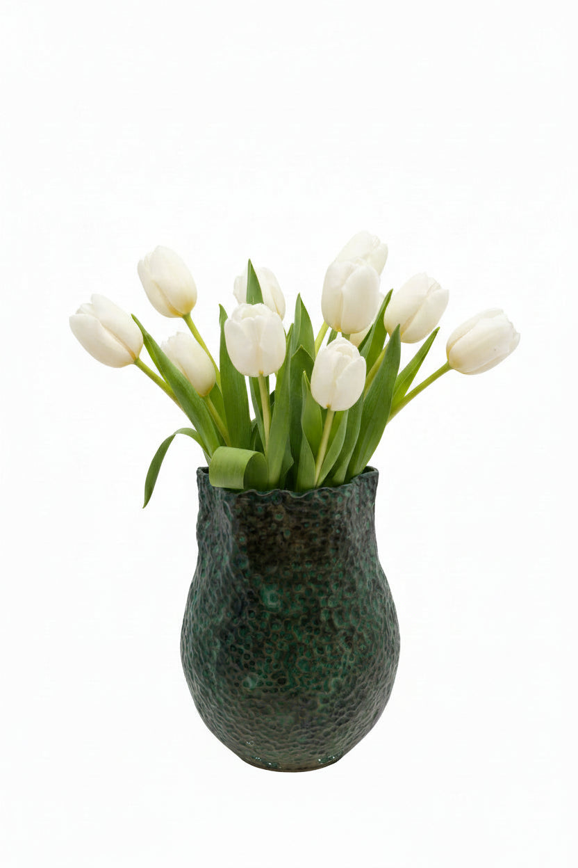 The tall green stoneware vessel styled with a bouquet of white tulips