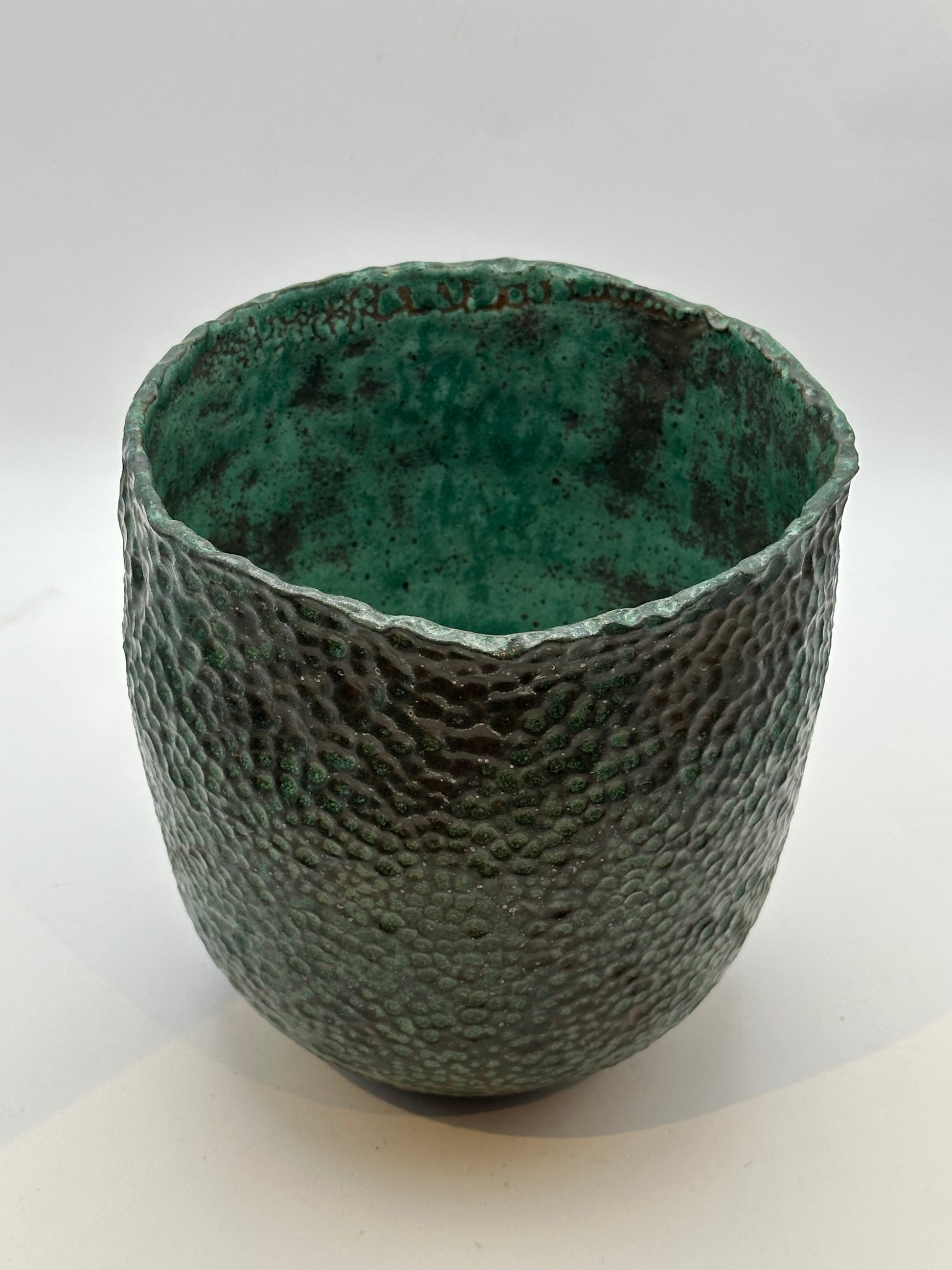 Front view of the wide-mouth stoneware vessel showing its mottled green interior glaze