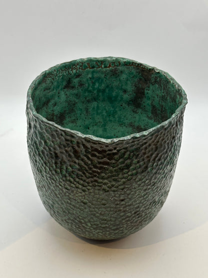 Front view of the wide-mouth stoneware vessel showing its mottled green interior glaze