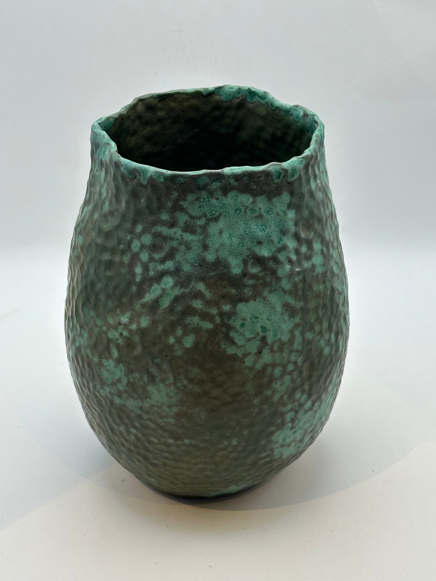 Front view of the medium green stoneware vessel showing its mottled verdigris glaze