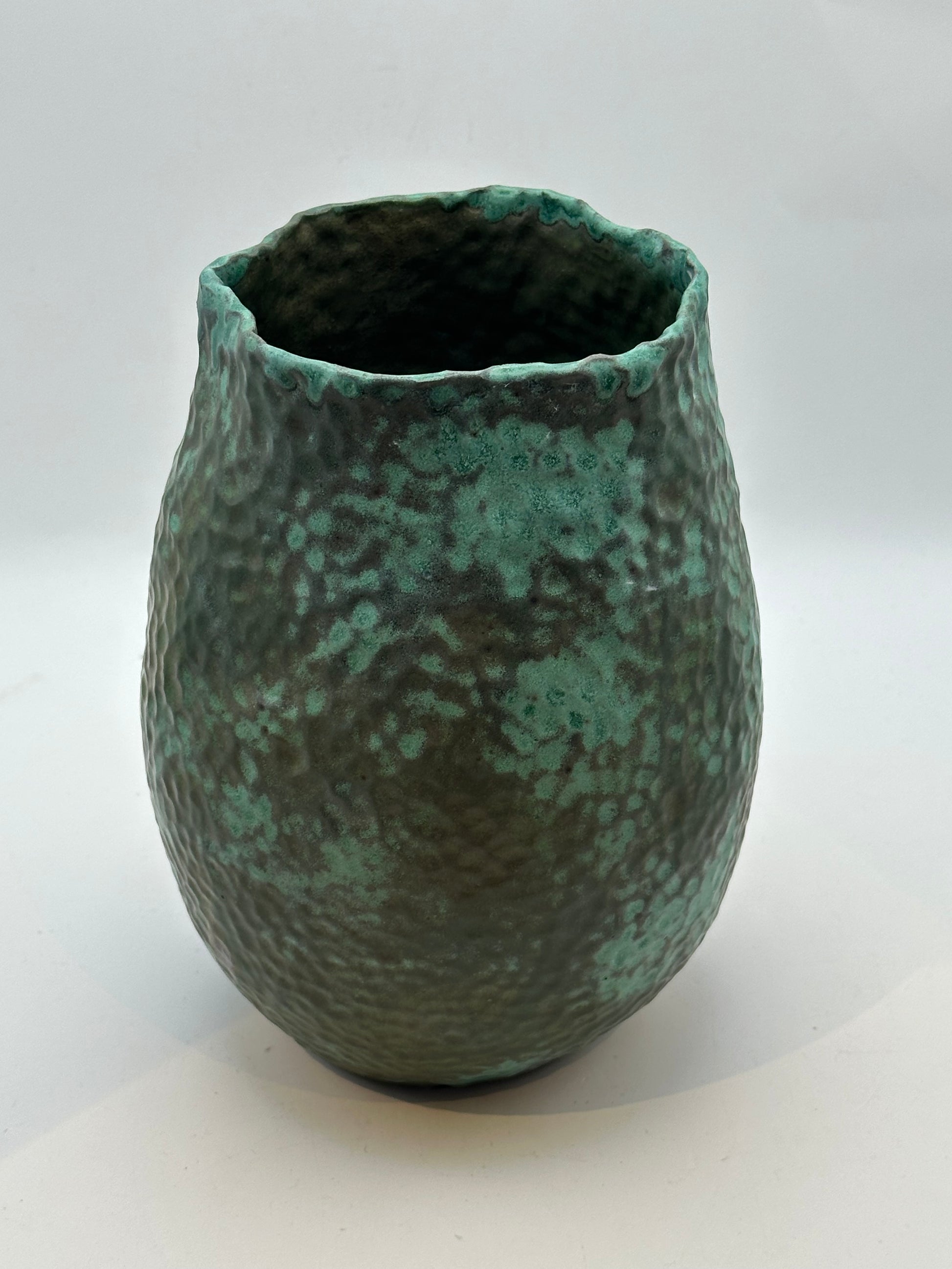 Front view of the medium green stoneware vessel showing its mottled verdigris glaze