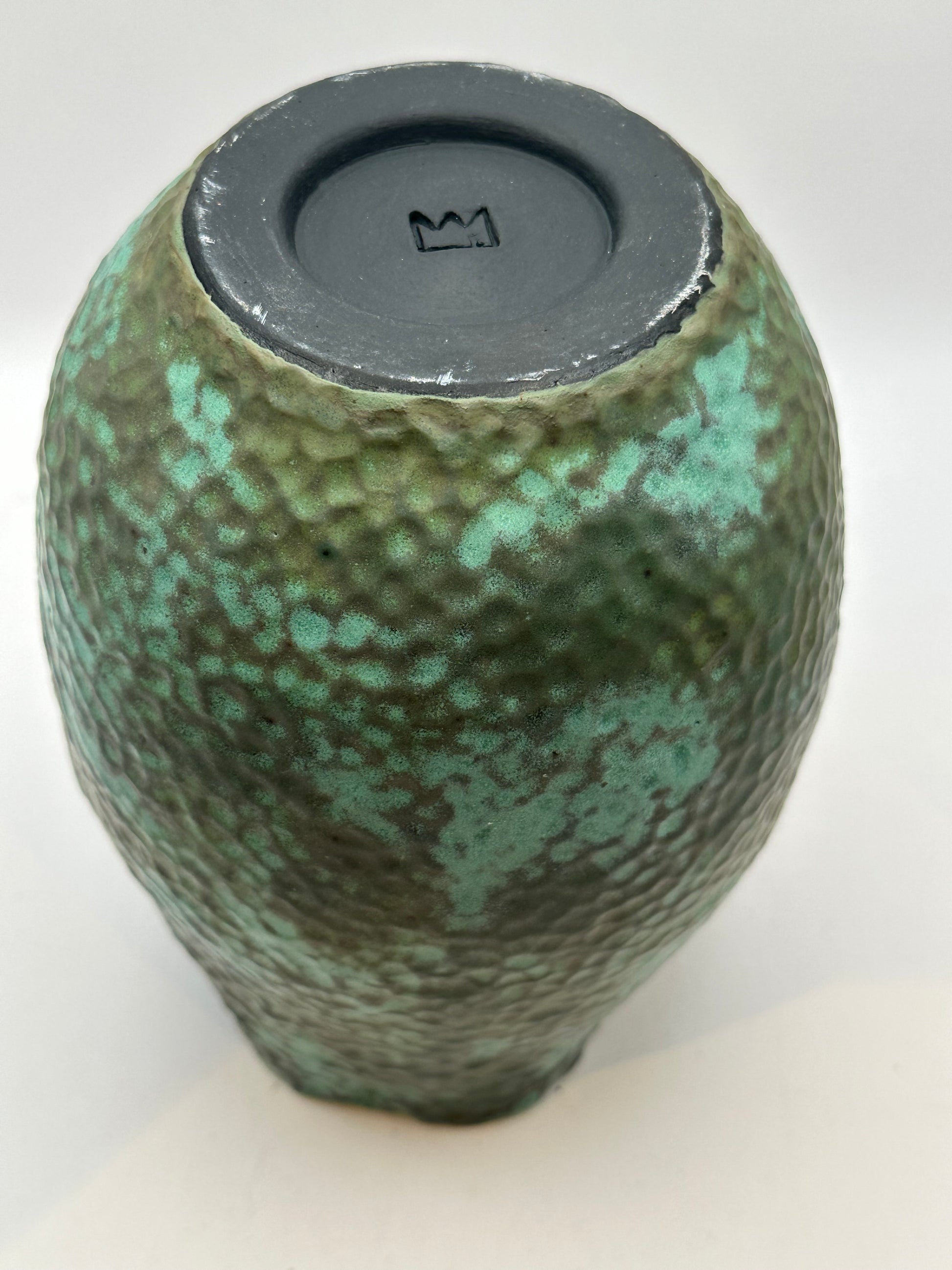 Underside of the medium stoneware vessel showing the recessed base with a crown maker's mark