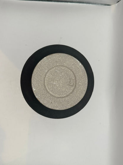 Top-down view of black stoneware vase showing speckled sandy lid and maker's mark.