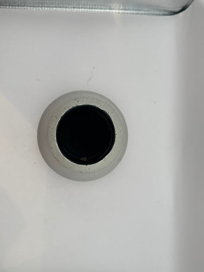 Top-down view into the white stoneware vessel's dark mouth and speckled rim.