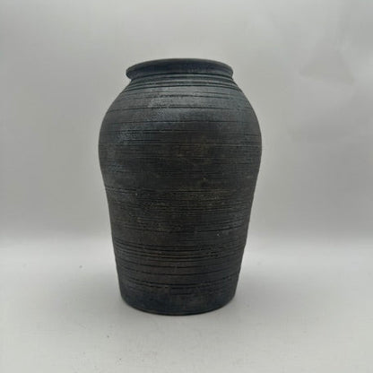 Black ribbed ginger-jar ceramic vase on gray backdrop, front view