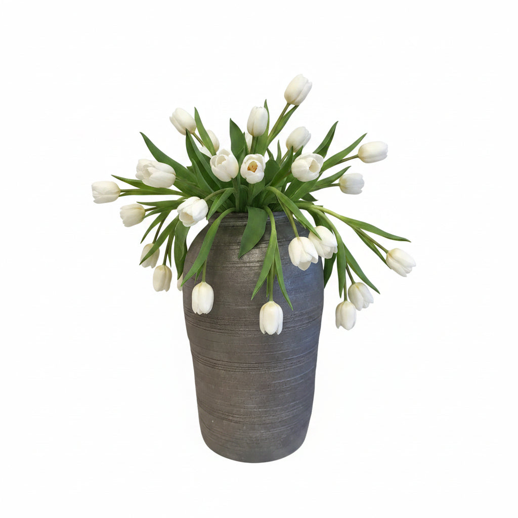 Grey ribbed ceramic tall vase holding white tulips, front view