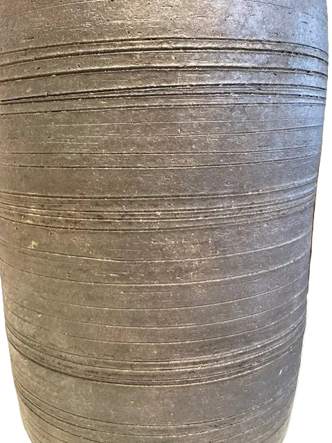 Extreme close-up of the grey vase's horizontal ribbed throwing-line texture
