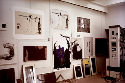 Robert Motherwell print book, photo of a studio wall displaying framed and pinned prints with a director's chair
