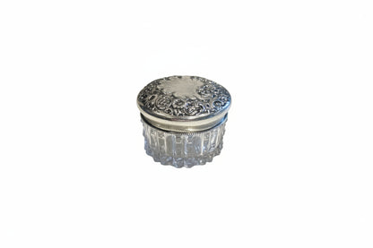 Vintage crystal and sterling petite dresser jar, closed with floral repoussé silver lid and fluted glass body.