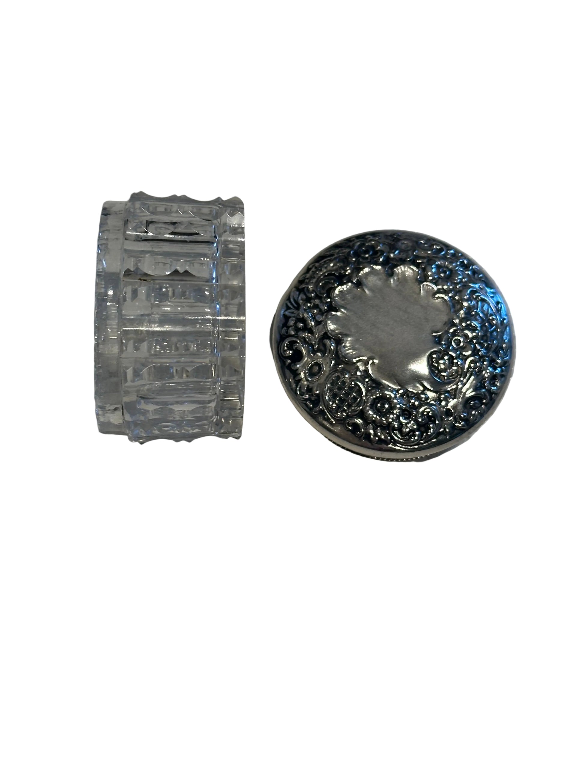 Vintage crystal and sterling petite dresser jar, fluted glass body on its side beside the silver lid.
