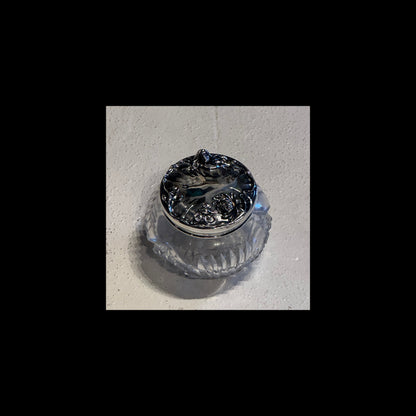 Antique crystal dresser jar viewed from above showing repoussé sterling silver floral lid