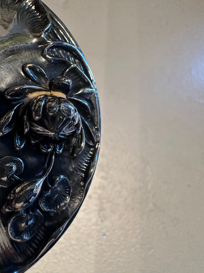 Close-up of sterling silver dresser jar lid showing Art Nouveau lotus and lily pad repousse