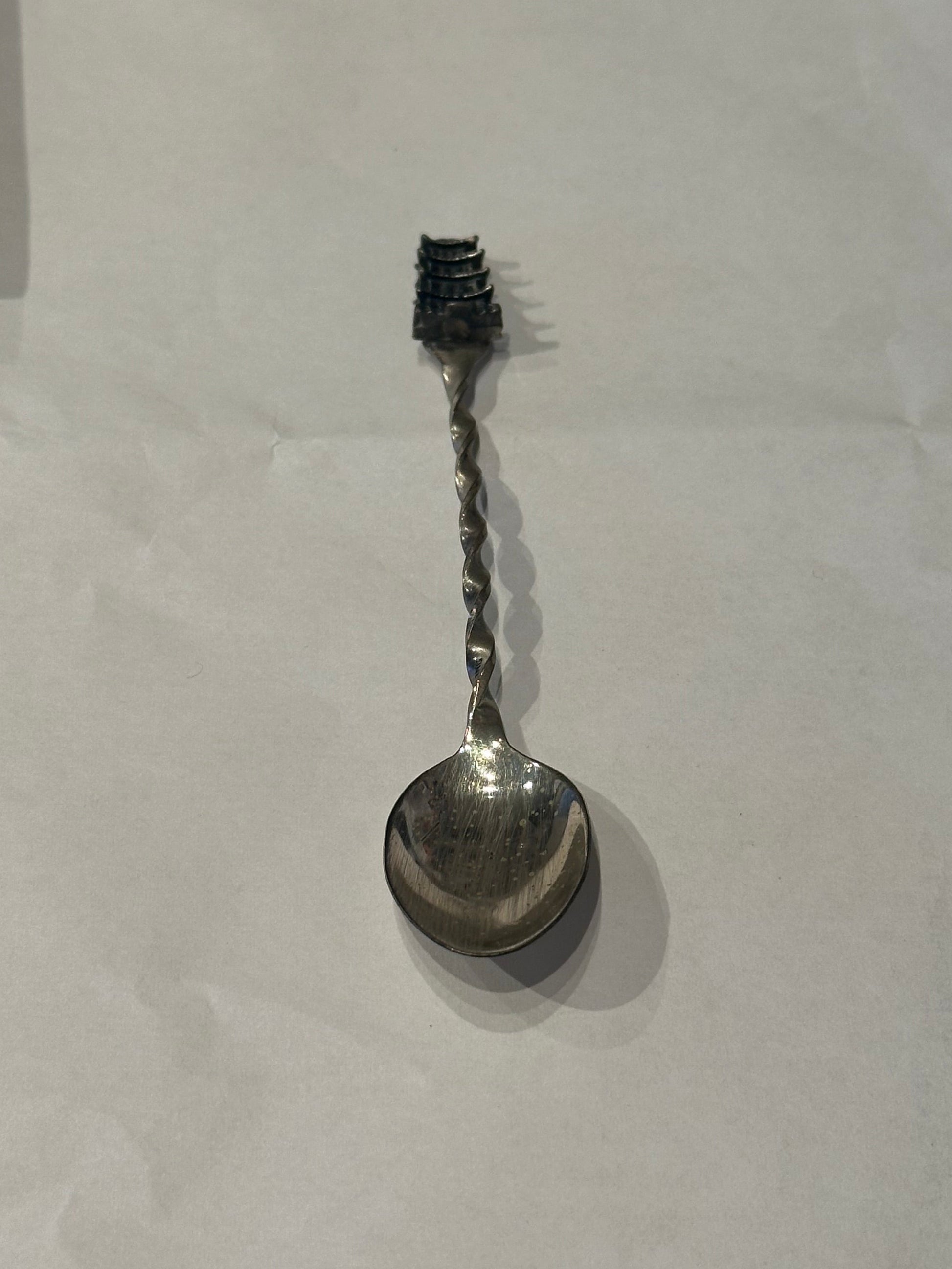 Sterling silver pagoda demitasse spoon, diagonal full view with pagoda finial above the twisted handle.