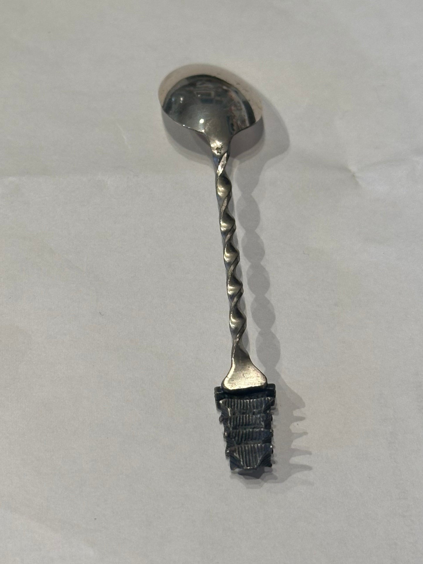 Sterling silver pagoda demitasse spoon, diagonal view showing the twisted handle and pagoda finial detail.