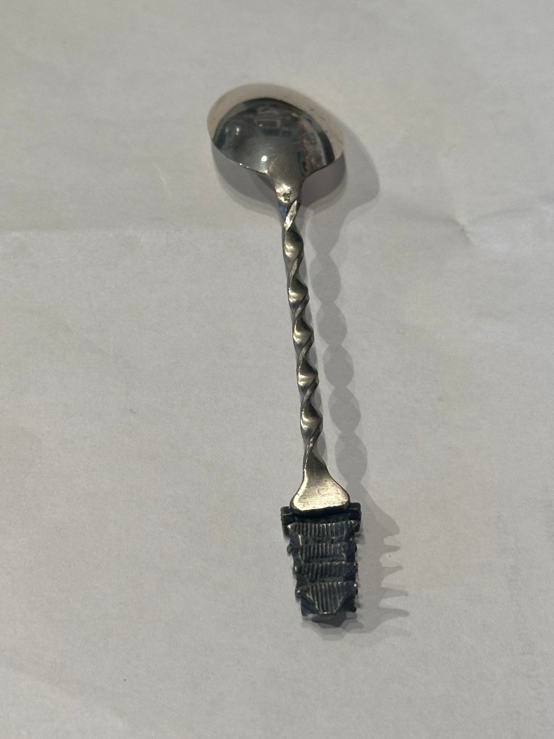 Sterling silver pagoda demitasse spoon, diagonal view showing the twisted handle and pagoda finial detail.