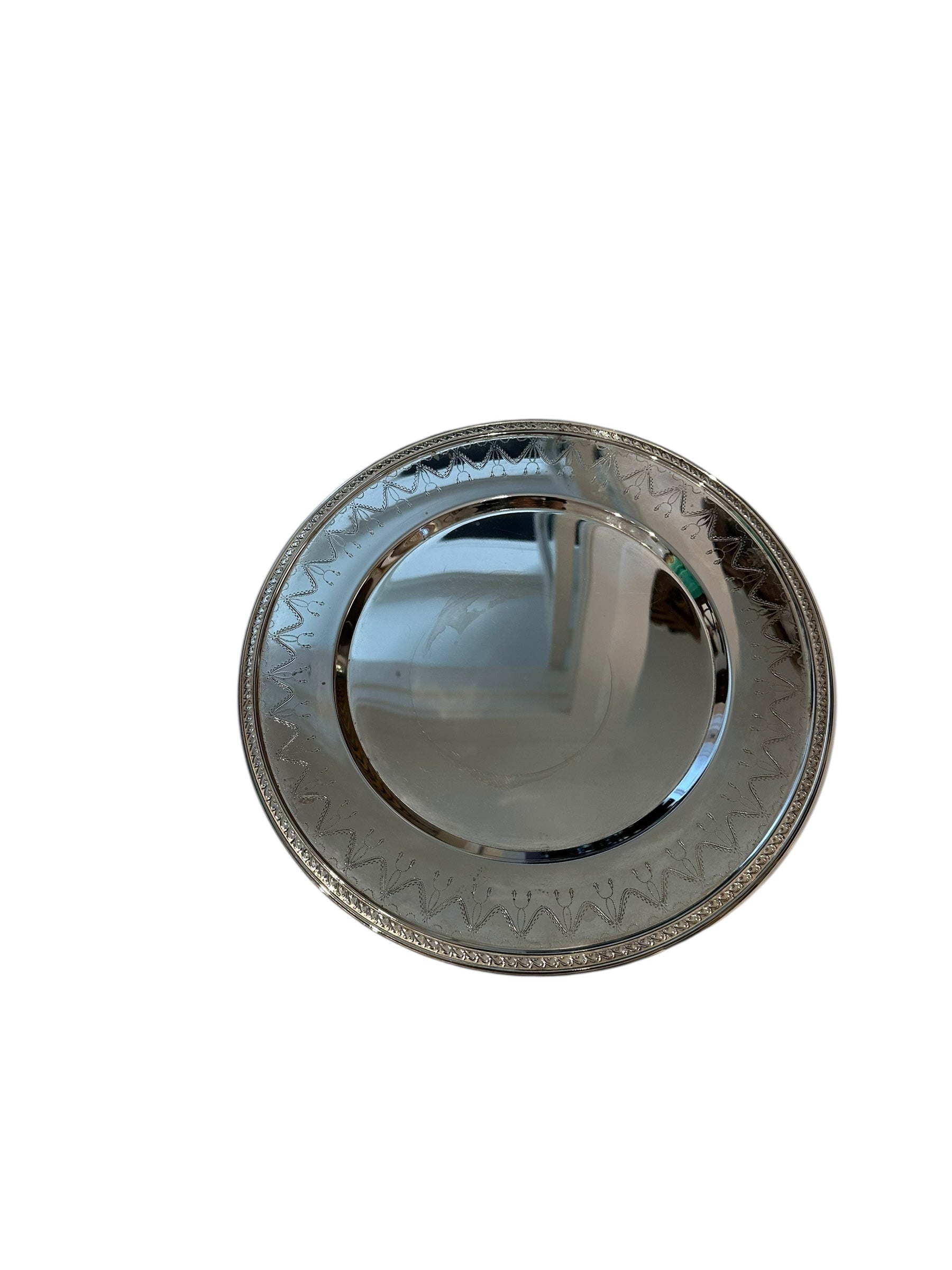 Vintage small round silverplate tray with engraved swag border, angled top view