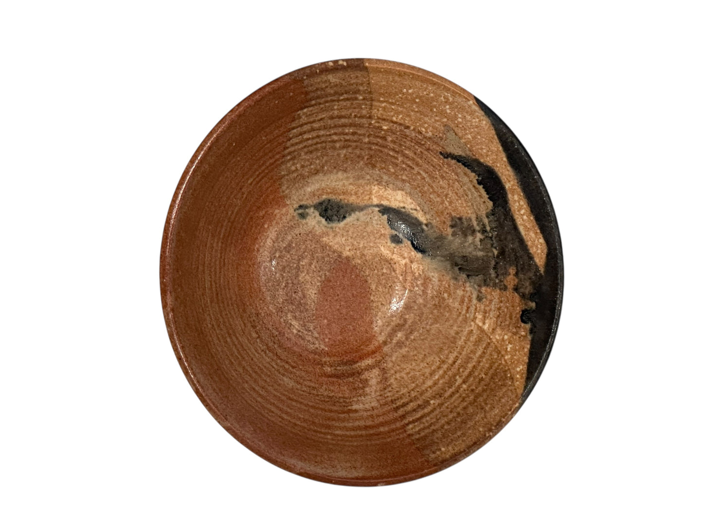 Interior of the studio pottery bowl showing rust glaze, spiral rings and dark accent glaze