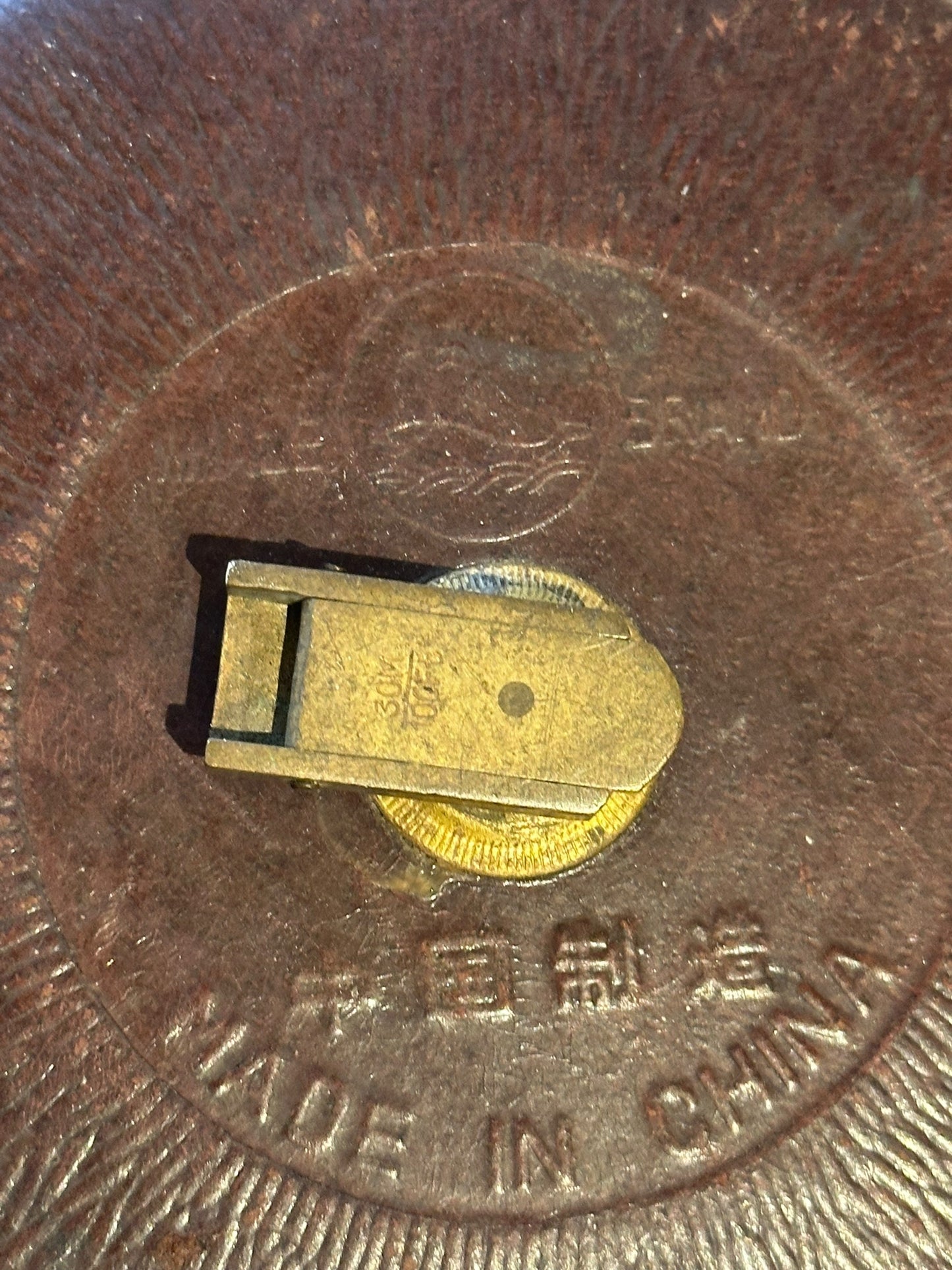 Close-up of the tape measure back showing brass tape clip and 'Made in China' embossing