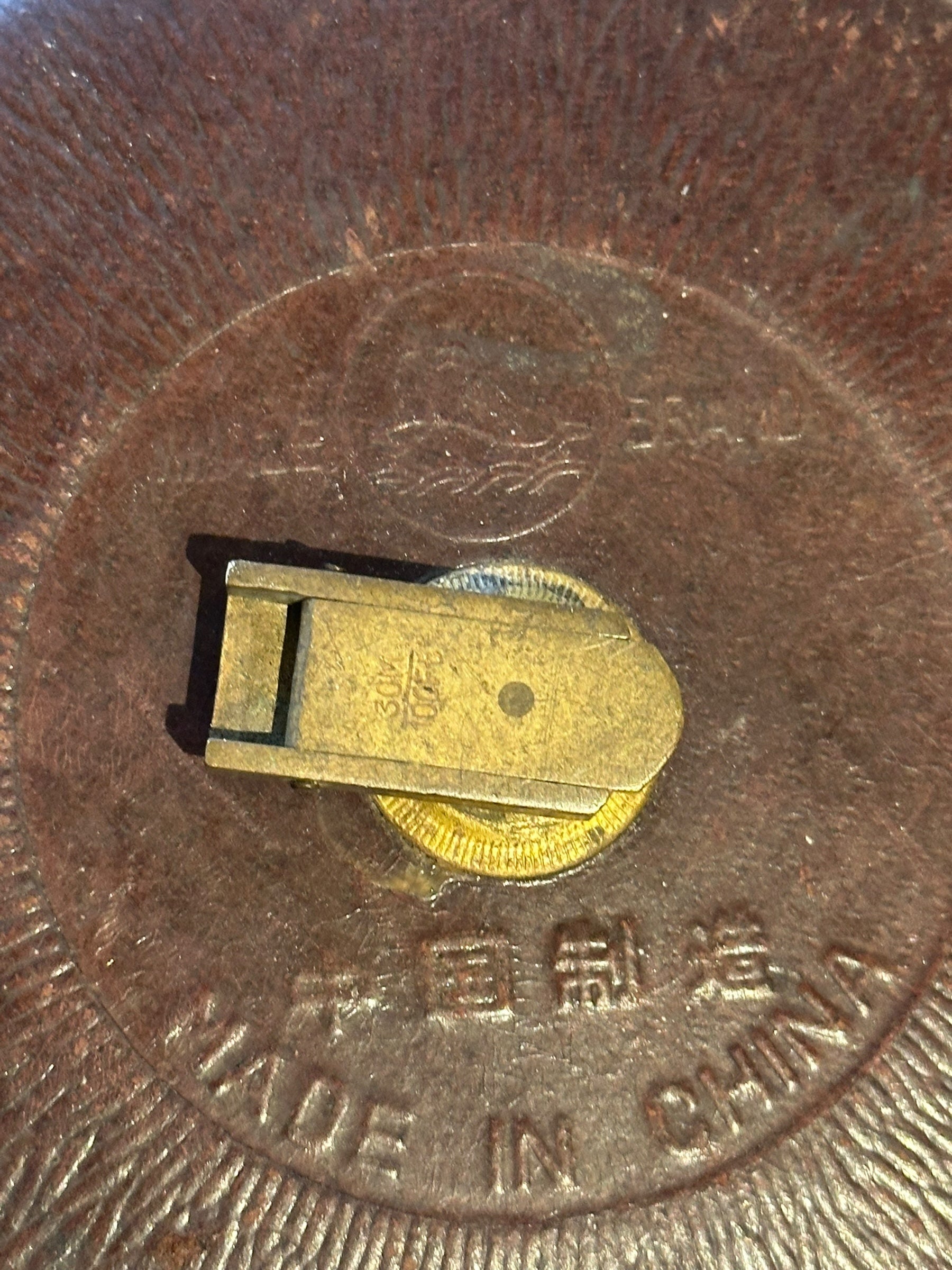 Close-up of the tape measure back showing brass tape clip and 'Made in China' embossing