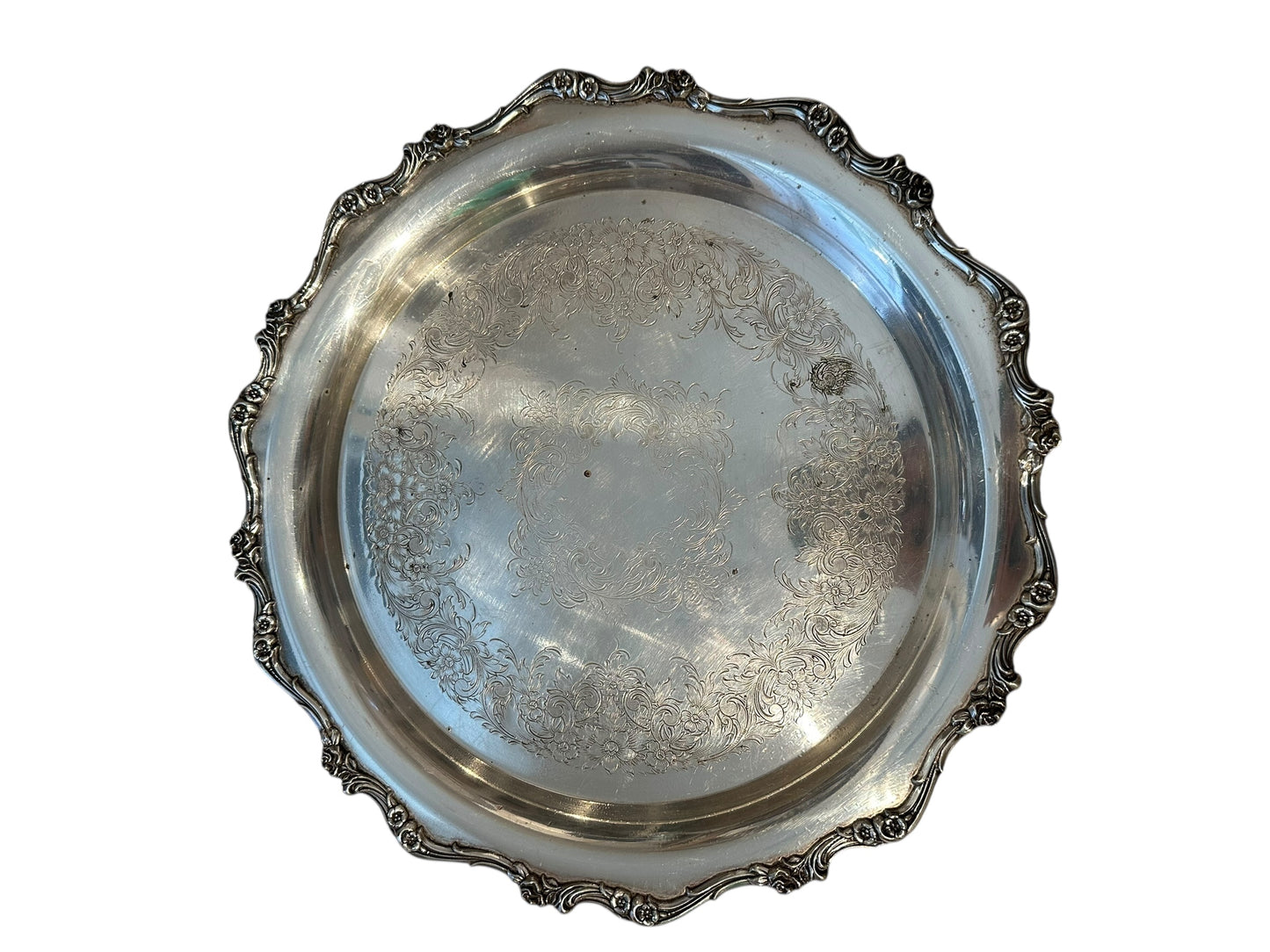 Vintage round silverplate serving tray with ornate scalloped scroll border and engraved floral center