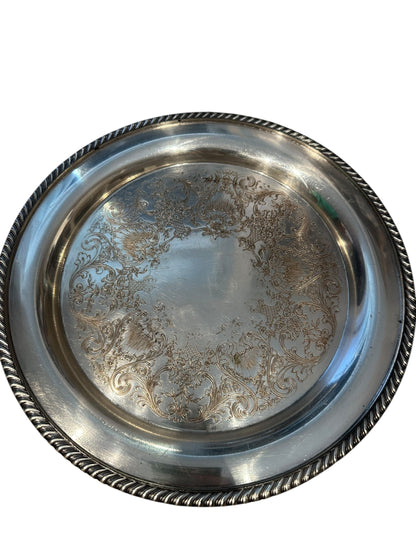 Vintage 11-inch silverplate serving tray, angled view of ornate engraved floral scrollwork interior