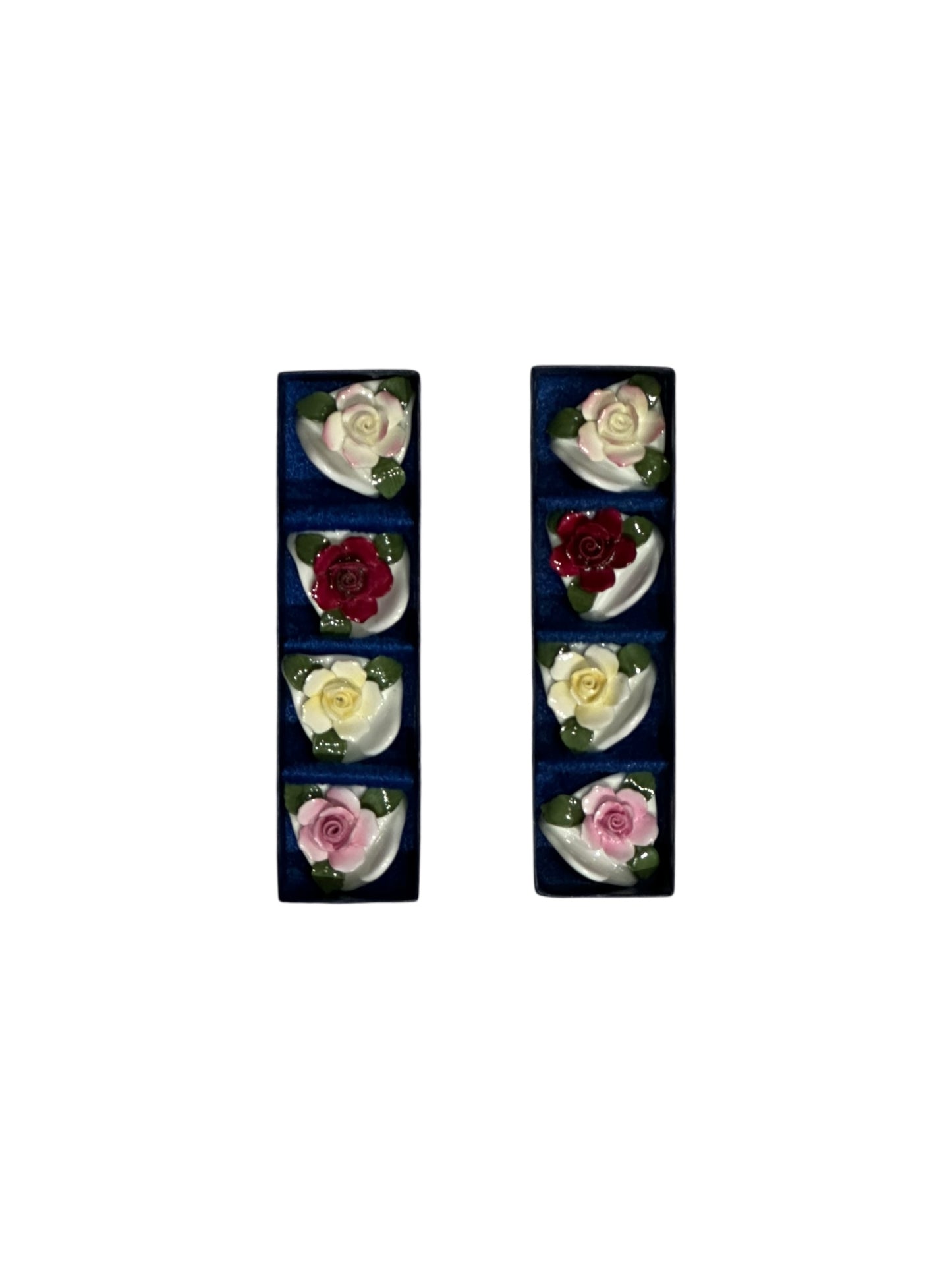 Porcelain rose place card holders displayed in two dark blue presentation boxes, top view