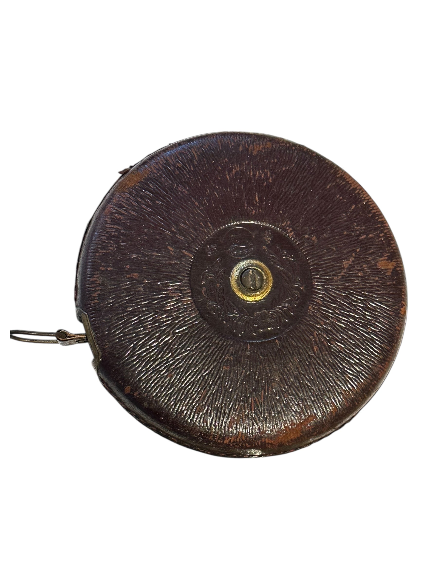 Antique leather-cased retractable tape measure showing embossed center fitting, front
