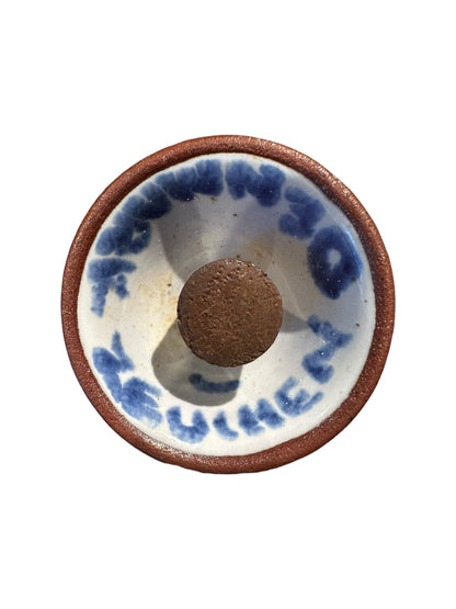 Underside of a mushroom shaker showing painted blue lettering and a cork stopper